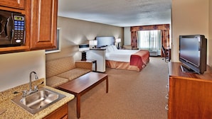 A hotel room with a kitchenette, a bed, a TV, and a seating area. - Holiday Inn Express Hotel & Suites Dubuque by IHG (Dubuque)