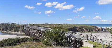 A coastal bridge with a view of the beach and ocean.