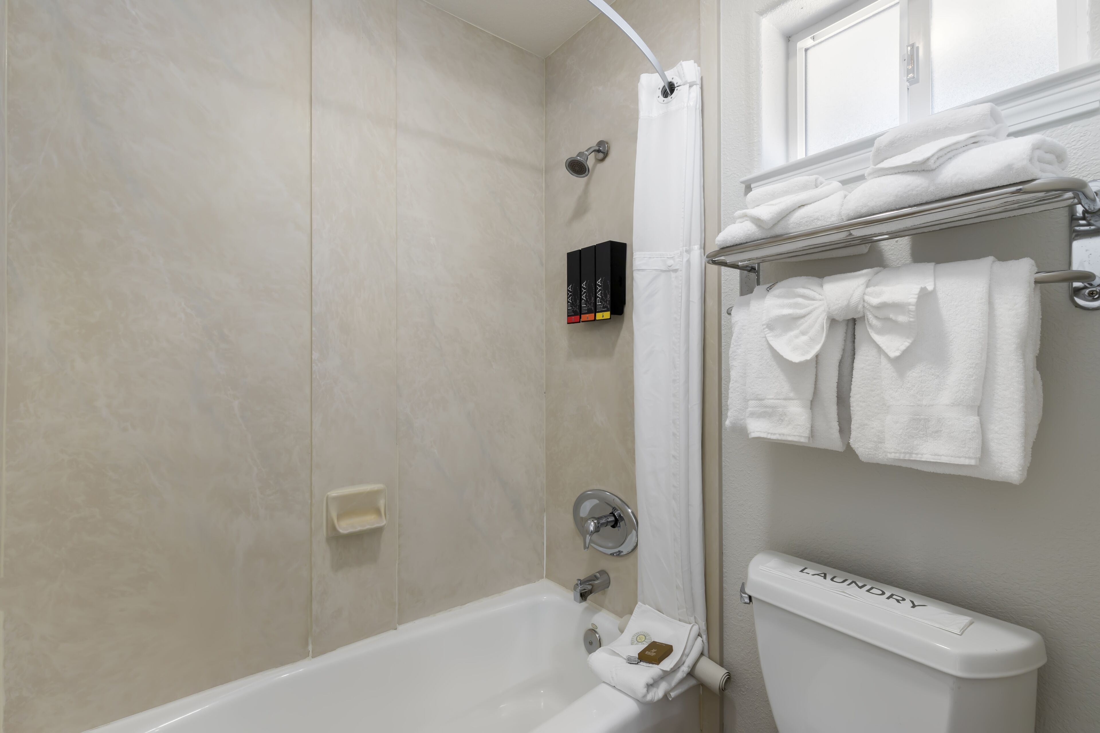 A bathroom with a bathtub, a toilet, and a shower area.