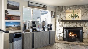 A reception area with a stone fireplace, a counter with various items, and framed pictures on the wall.