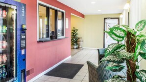 A hotel lobby with a vending machine, a reception desk, and a large potted plant. - Rodeway Inn Shippensburg I-81 (Shippensburg)