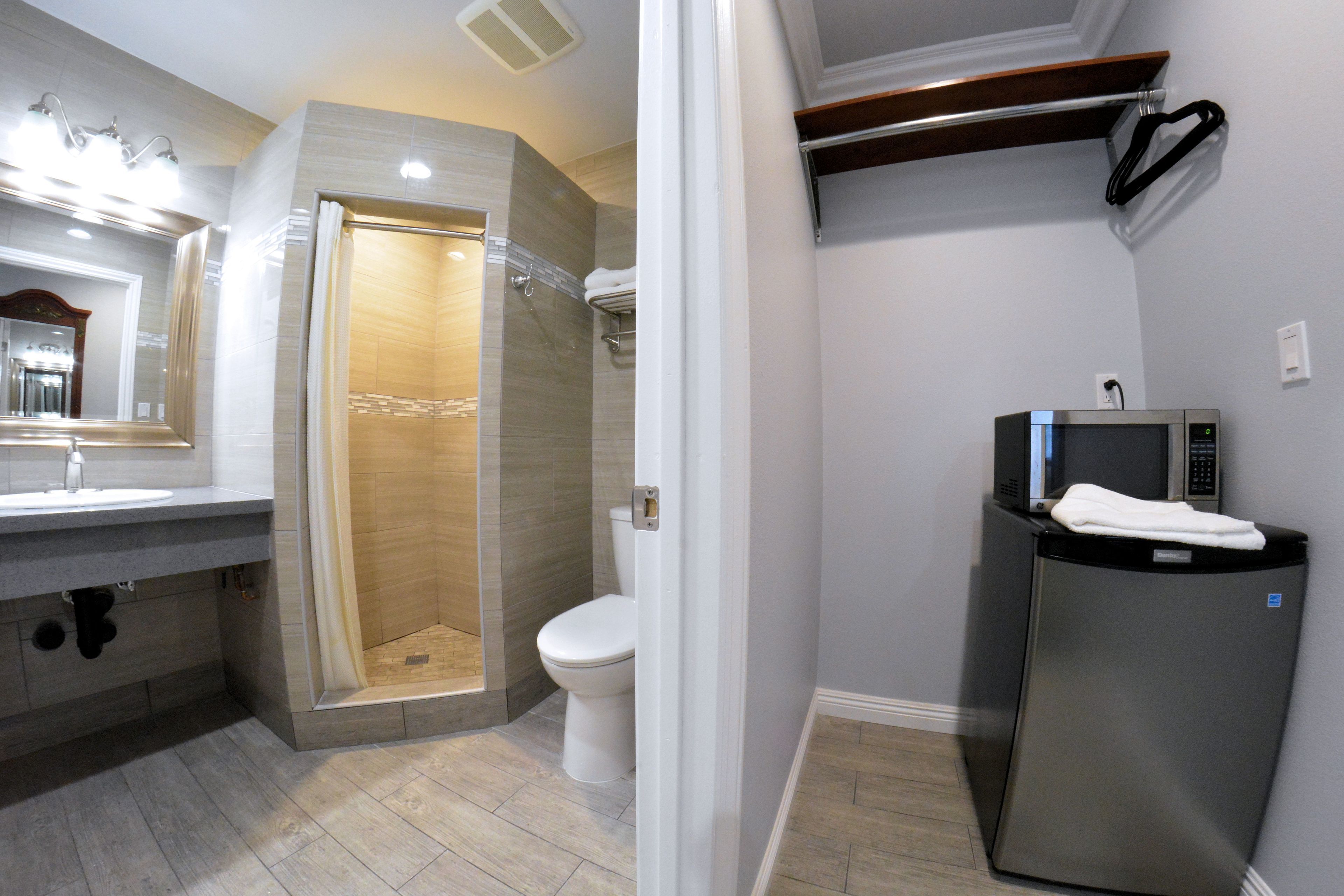 A modern bathroom with a shower, toilet, and a built-in microwave.