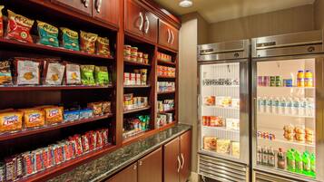 Una estación autoservicio de aperitivos y bebidas con diferentes alimentos y refrescos envasados.