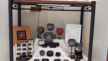 A display of various mugs and candles on a shelf.