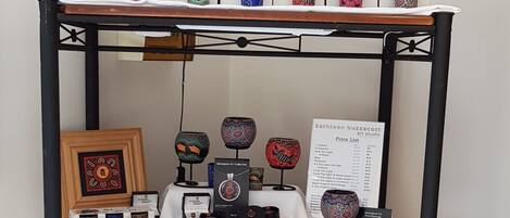 A display of various mugs and candles on a shelf.