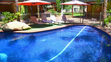 Alberca al aire libre y camastros