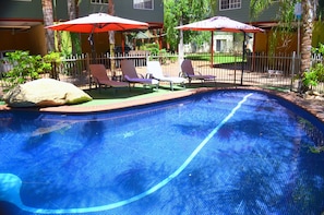 Alberca al aire libre y camastros