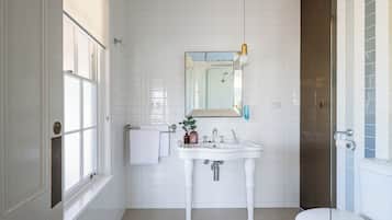 A bathroom with a white sink, mirror, and toilet.