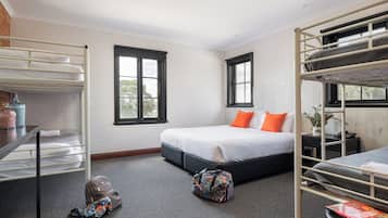 A room with bunk beds, a desk, and a window.