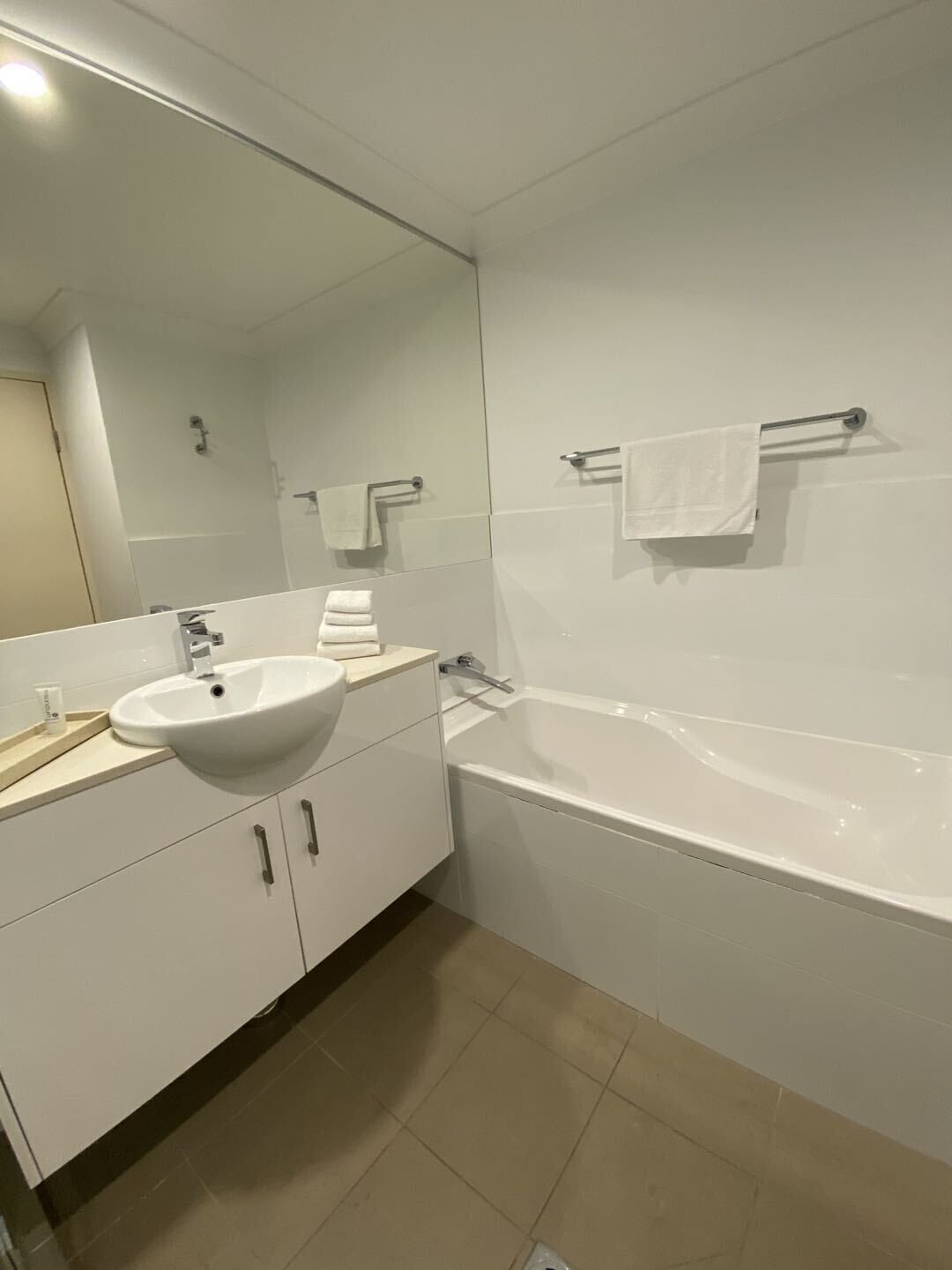 Ein modernes Badezimmer mit Waschbecken, Spiegel und Badewanne.