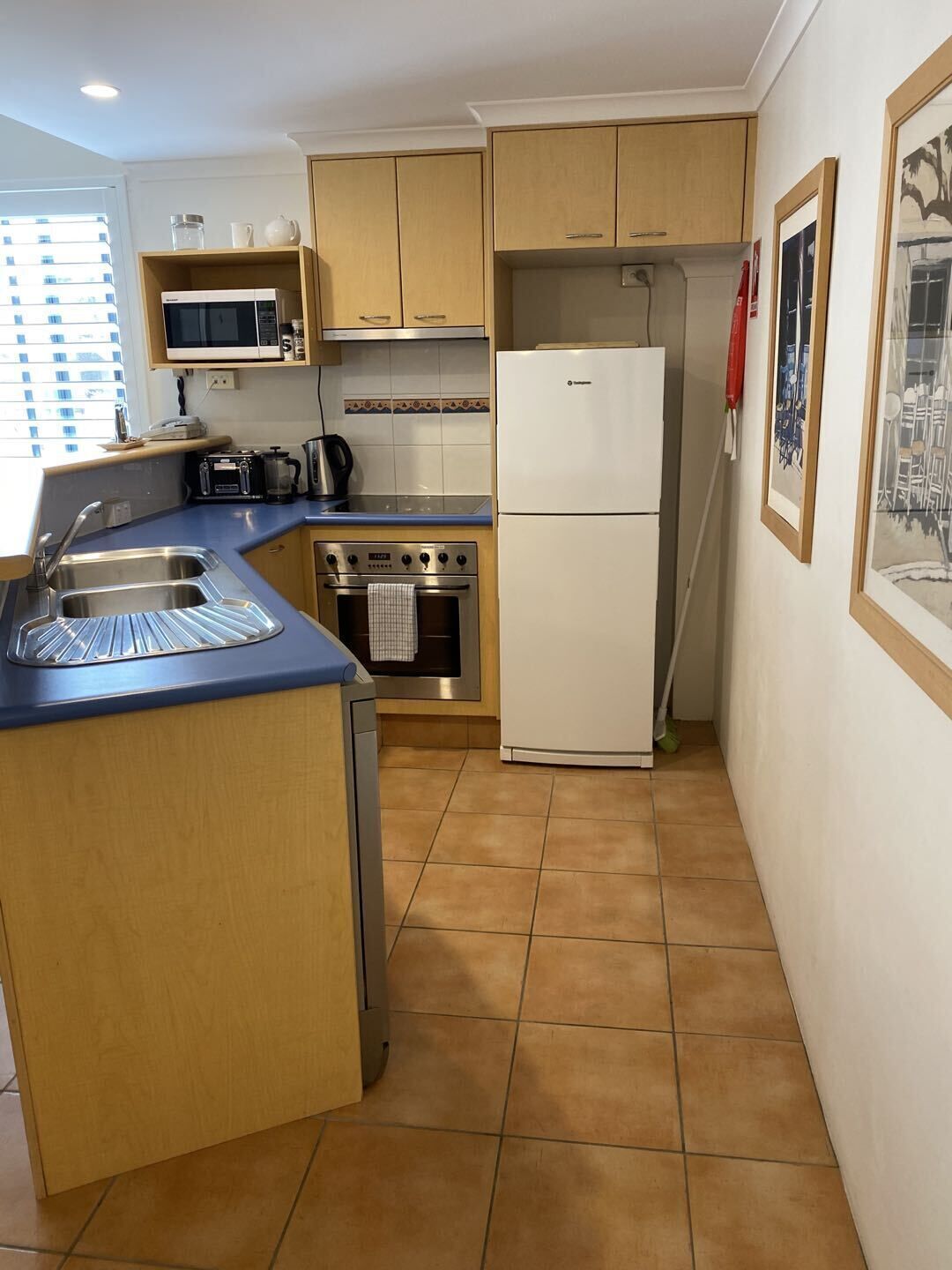 Una cocina compacta equipada con microondas, estufa y refrigerador.
