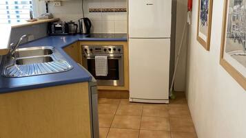 Una cocina compacta equipada con microondas, estufa y refrigerador.