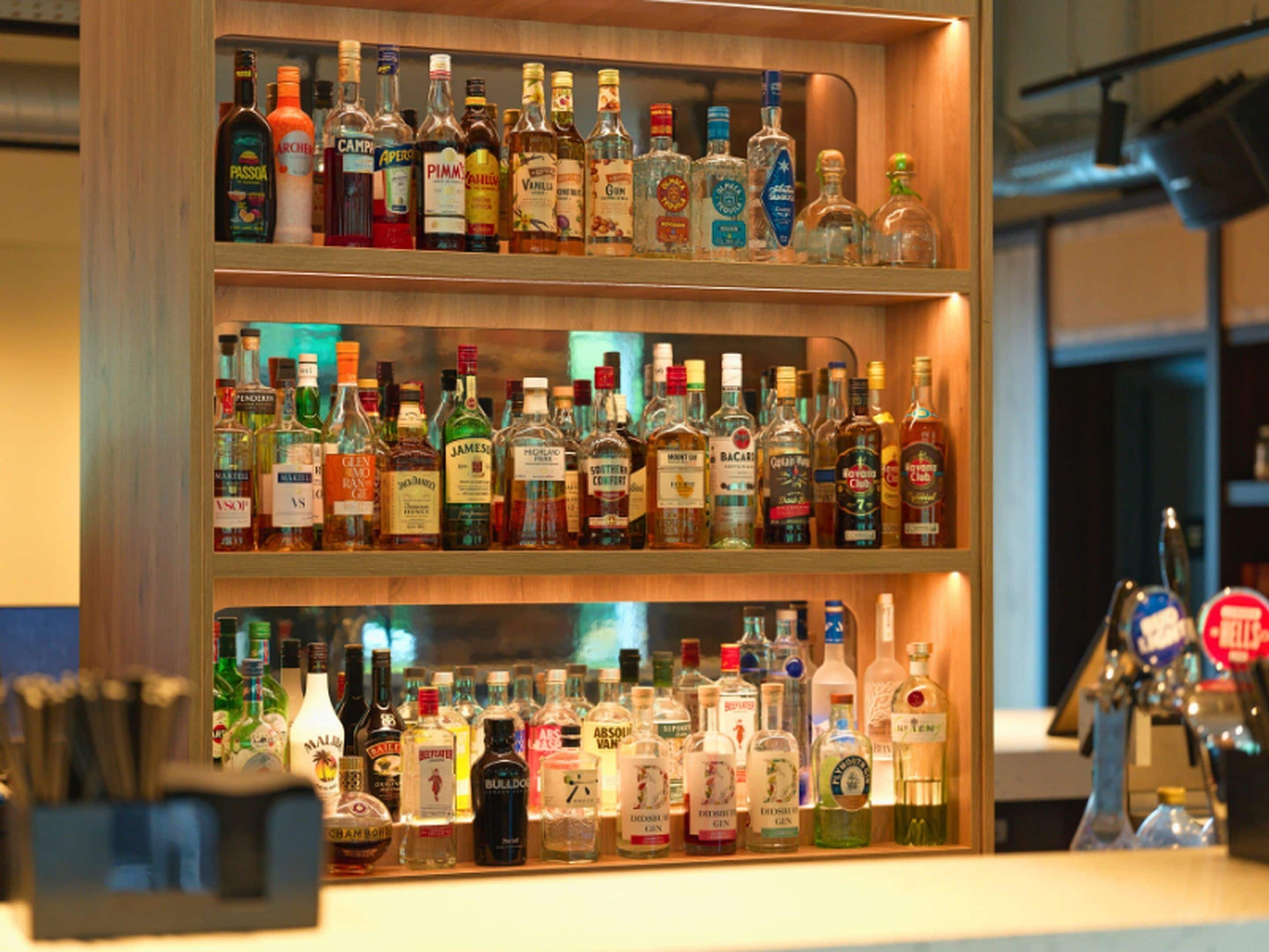 A bar with shelves of various liquor bottles.