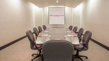 Une salle de conférence équipée d’une longue table, de chaises et d’un écran de présentation.