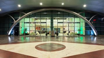A modern building with a curved glass facade, a central atrium, and a patterned floor.