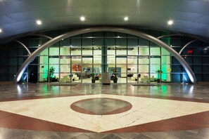 A modern building with a curved glass facade, a central atrium, and a patterned floor. - Crowne Plaza Leon by IHG (León)