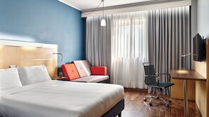 A modern hotel room with a large bed, a desk, a chair, and a TV. - Holiday Inn Express Milan - Malpensa Airport by IHG (Somma Lombardo)