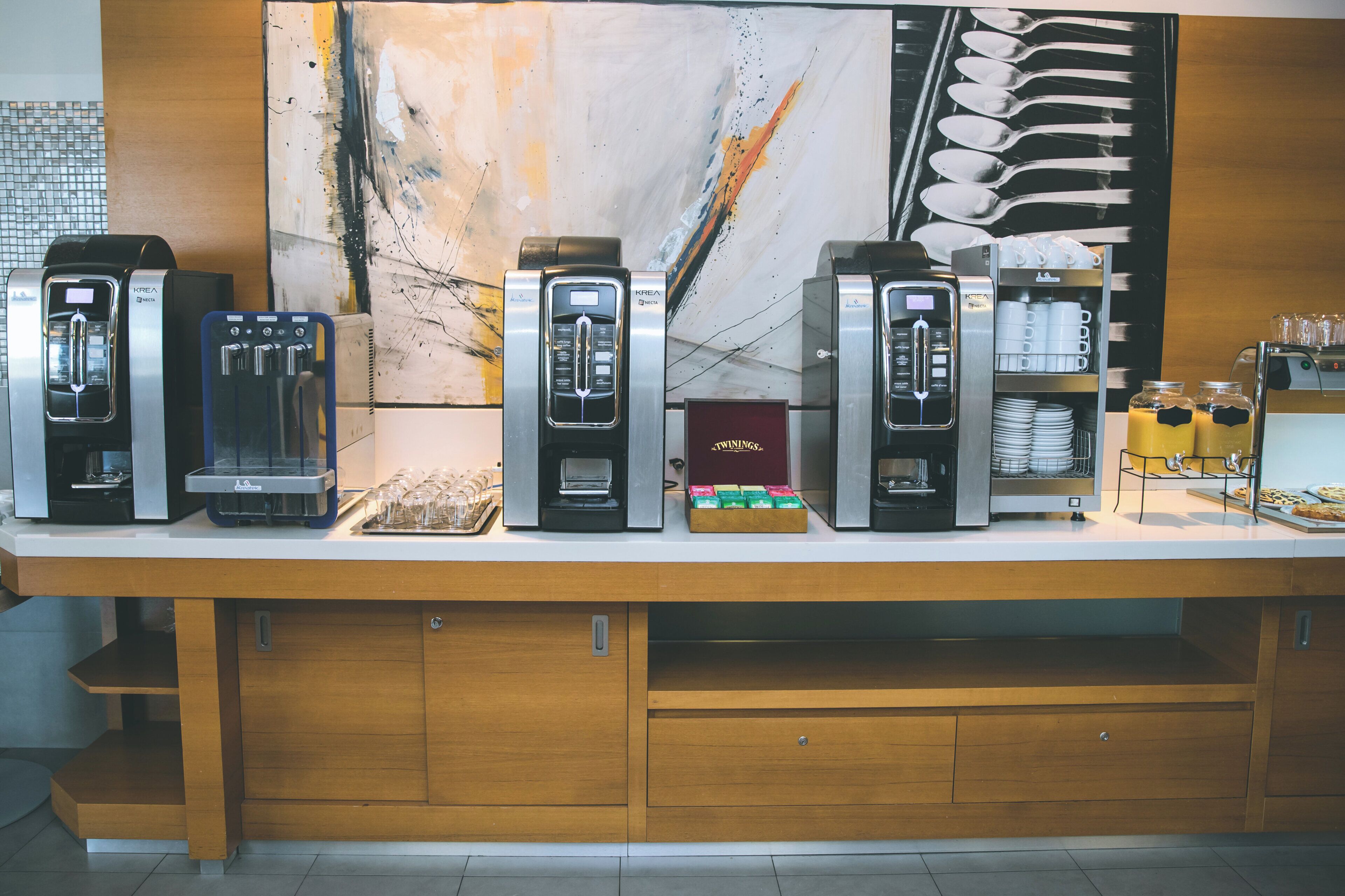 Un angolo caffè con diverse macchine e una selezione di bevande a base di caffè.