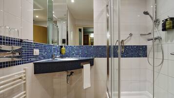 Une salle de bain moderne avec une douche à parois de verre, un lavabo avec une serviette et un miroir.