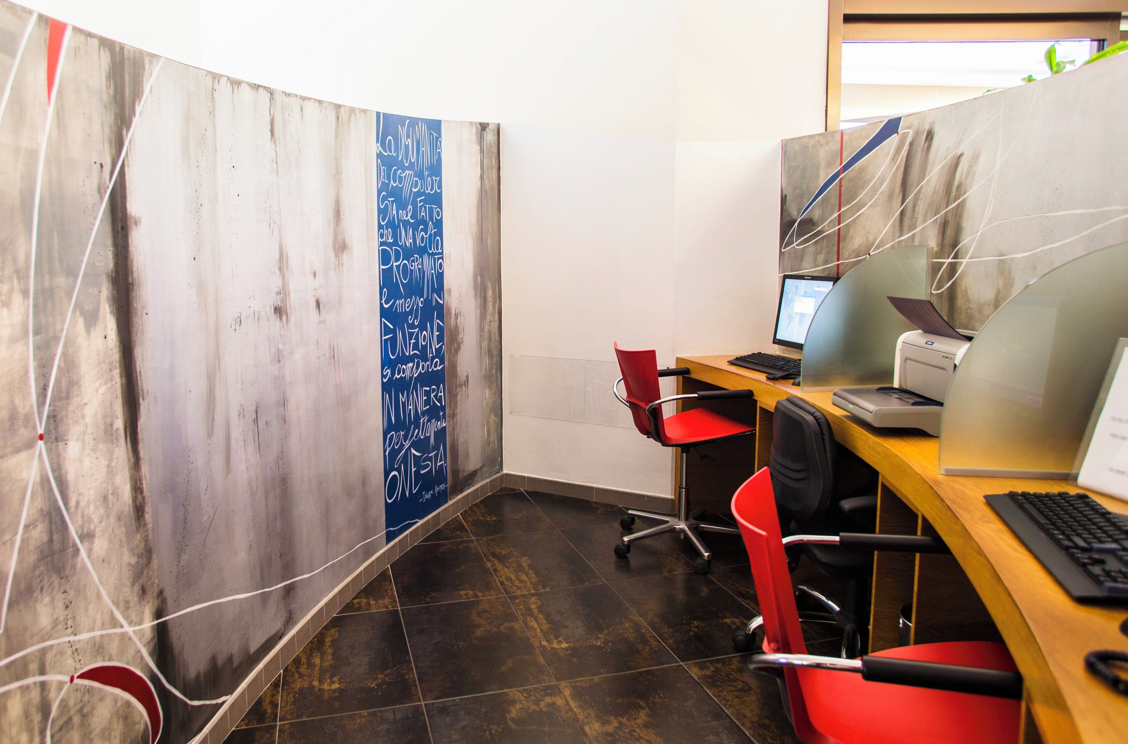 Een moderne kantoorruimte met een gebogen scheidingswand, een bureau met een computer en een stoel.