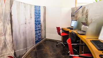 A modern office space with a curved partition, a desk with a computer, and a chair.