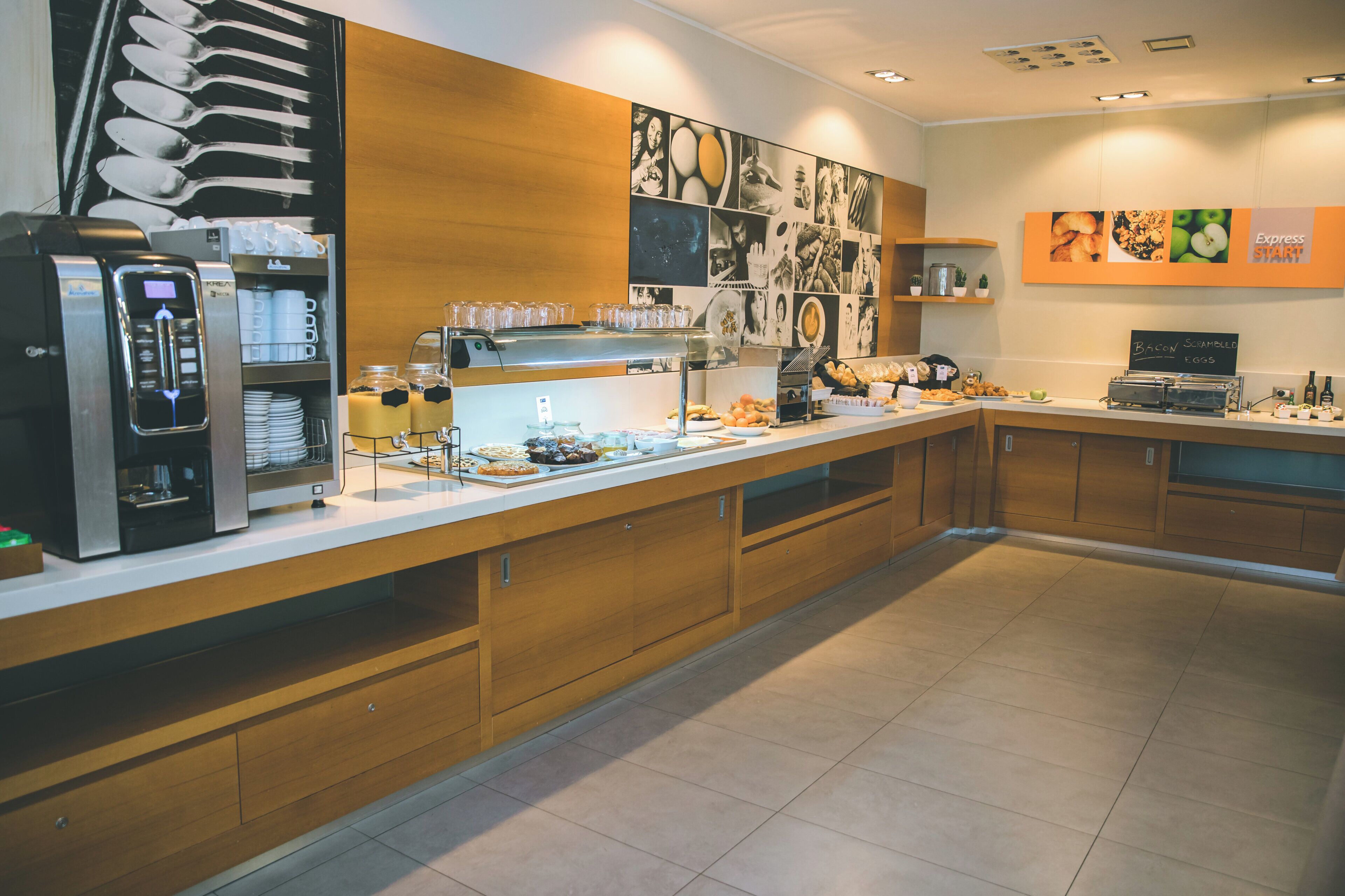 A buffet area with a self-service beverage station, a variety of food items, and a chalkboard menu.