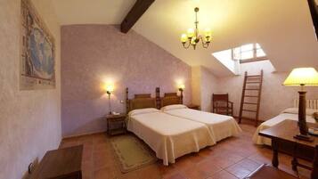 Une chambre avec deux lits, un bureau en bois, une chaise, une échelle et un lustre.