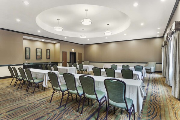 A conference room with a long table, chairs, and a carpeted floor.