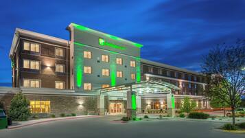 Un hotel Holiday Inn Express con una fachada moderna, un acceso cubierto y un área de estacionamiento bien iluminada.