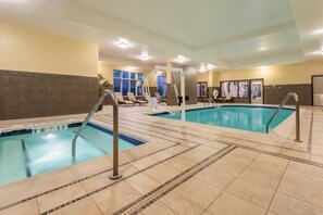 An indoor swimming pool with multiple lanes, lounge chairs, and a sun terrace. - Holiday Inn & Suites Grand Junction-Airport by IHG (Grand Junction)
