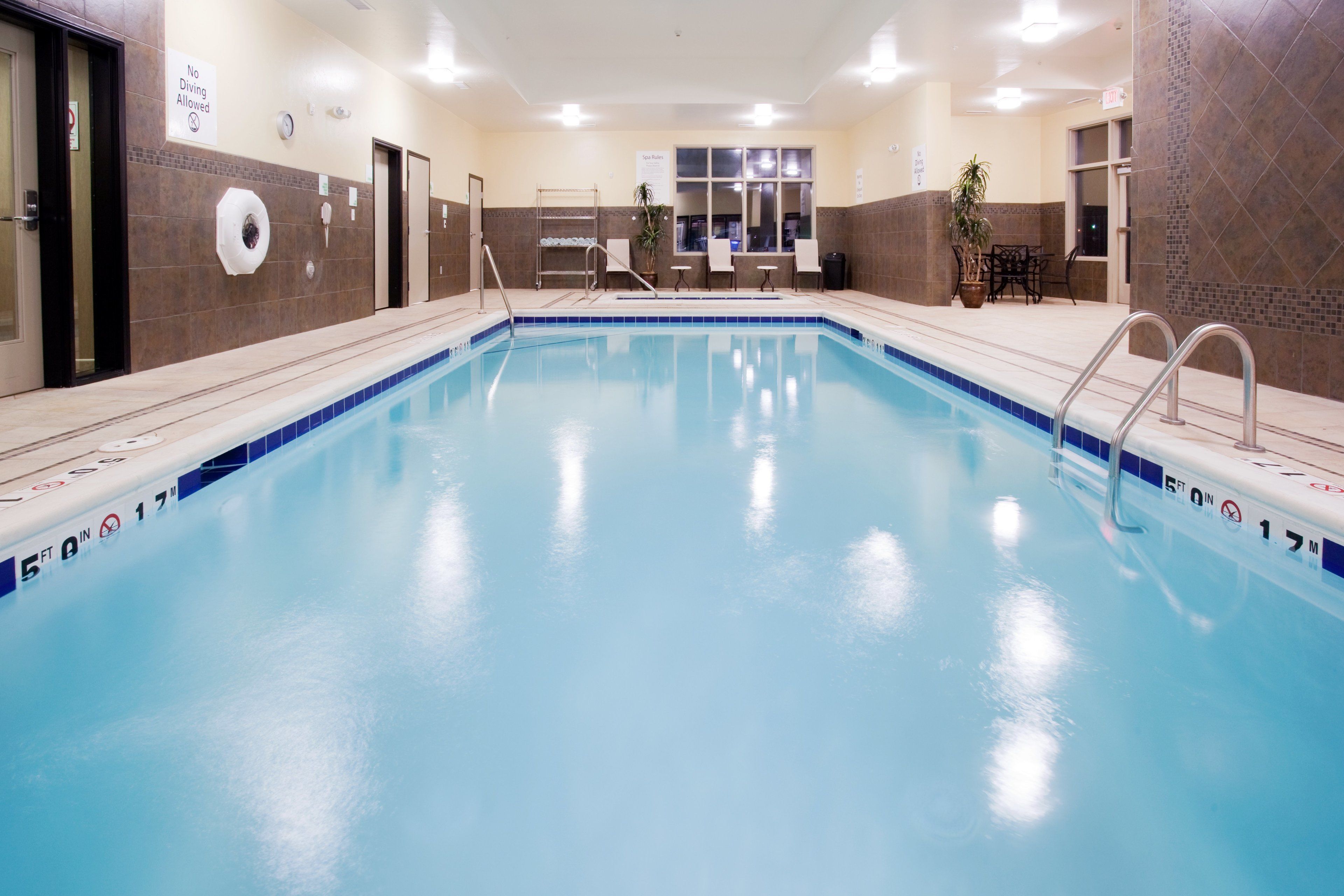 Una piscina techada, sillones reclinables de piscina