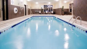 Una piscina techada, sillones reclinables de piscina