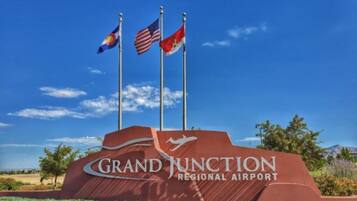 A sign for Grand Junction Regional Airport with three flags.