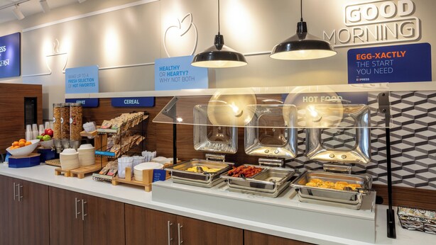 A breakfast buffet with various food options and a sign that reads "GOOD MORNING".