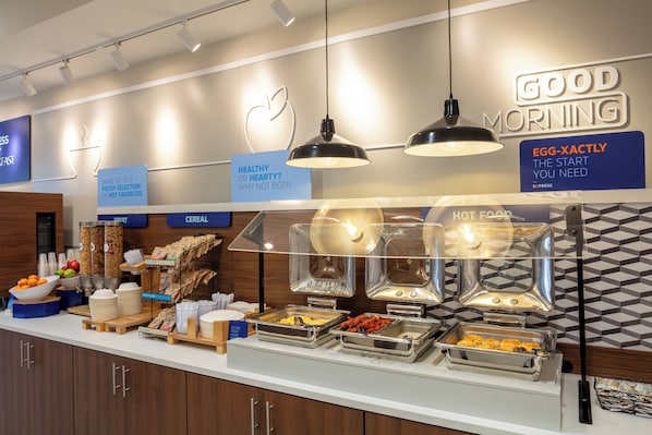 A breakfast buffet with various food options and a sign that reads "GOOD MORNING".