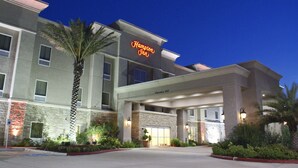 A Hampton Inn hotel with a clear entrance, stone facade, and illuminated signage. - Hampton Inn Orange (Orange)