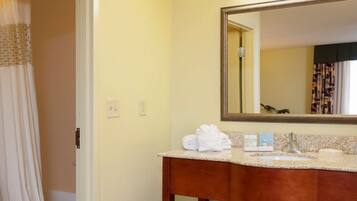 A bathroom with a sink, mirror, and towel rack.