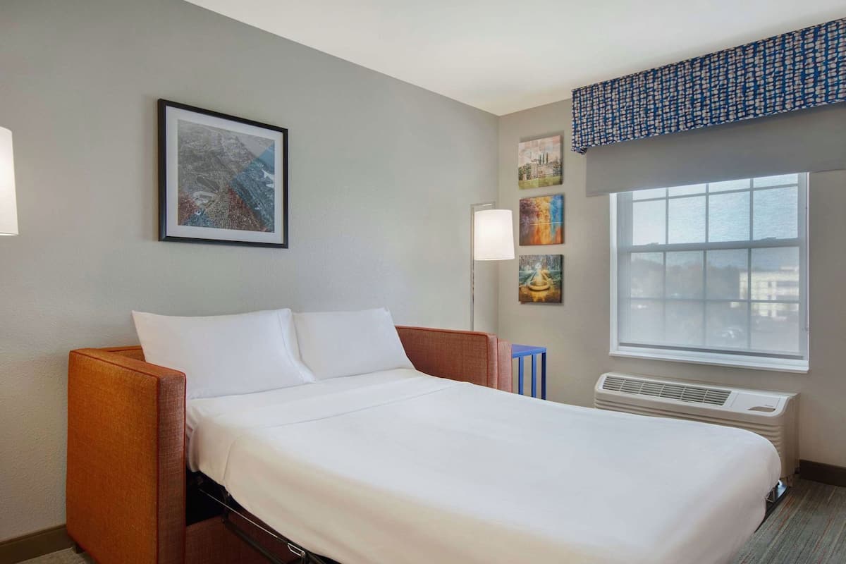 Premium bedding, desk, laptop workspace, blackout drapes