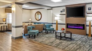 A hotel lobby with a fireplace, comfortable seating, and a large TV screen. - Sleep Inn & Suites Hiram - Atlanta Northwest (Hiram)