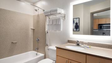 A modern bathroom with a bathtub, toilet, and a sink.