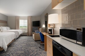 A hotel room with two beds, a desk with a microwave, a coffee maker, and a TV. - Candlewood Suites Watertown Fort Drum by IHG (Evans Mills)