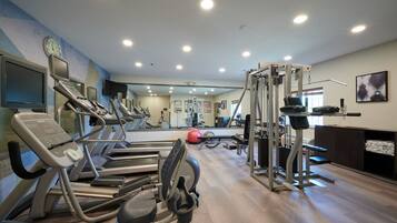 A gym with treadmills, elliptical machines, and weightlifting equipment.