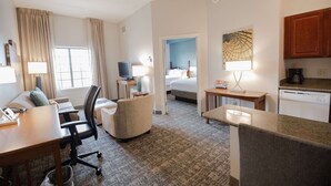 A hotel room with a desk, chair, bed, kitchenette, and a bathroom. - Sonesta ES Suites Baton Rouge University at Southgate (Baton Rouge)