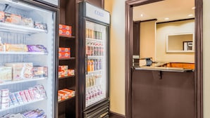 Un hall d’hôtel doté d’un espace de stockage réfrigéré contenant des collations, des boissons et des produits d’entretien.