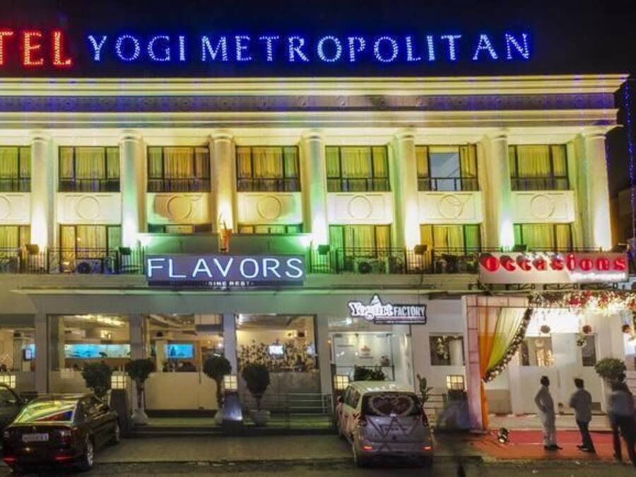 Un hotel llamado 'HOTEL YOGI METROPOLITAN' con letreros que dicen 'FLAVORS' y 'Occasions'.