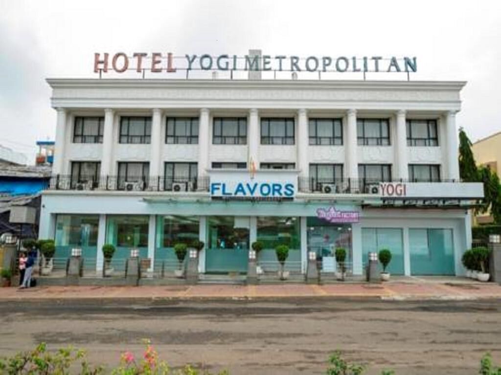 A hotel named 'Hotel Yogimetroplitan' with a sign for 'Flavors' and 'Yogi' on the ground floor.
