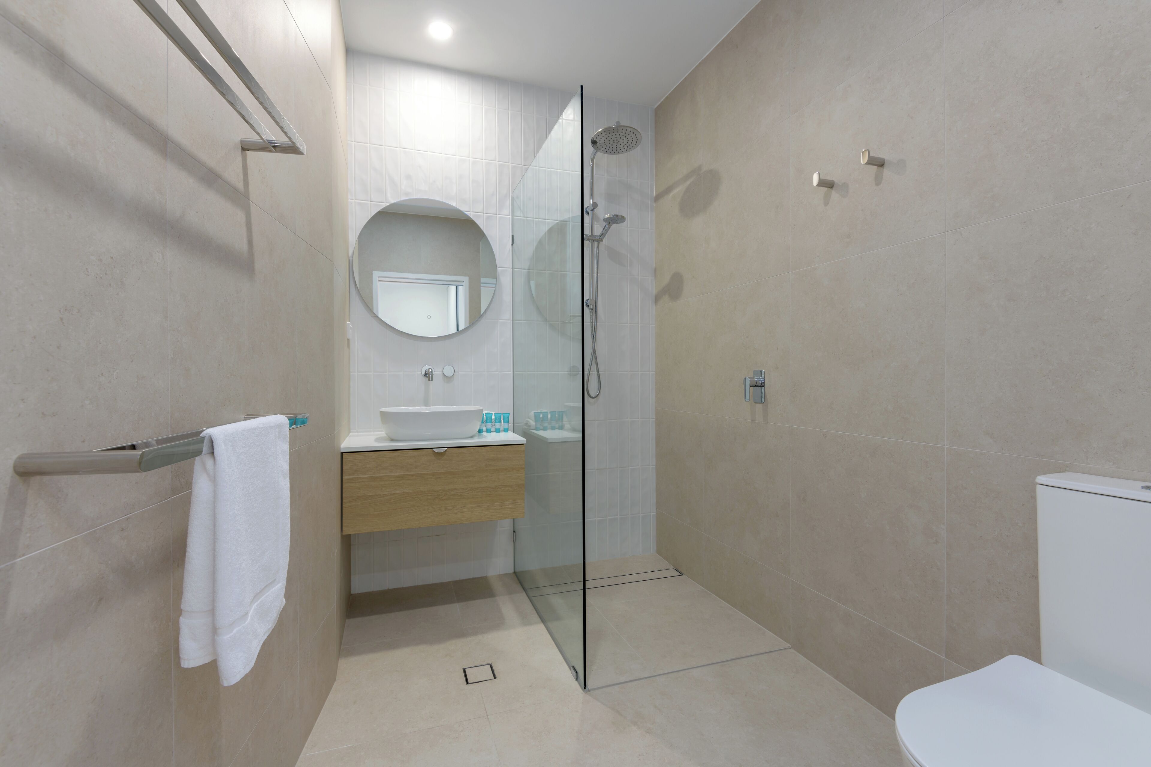Une salle de bain moderne avec une douche à parois de verre, un lavabo blanc et des toilettes.