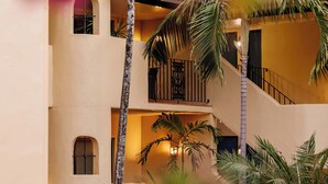 A multi-story building with a central staircase, surrounded by palm trees and greenery. - Villa San Michele (Port Douglas)