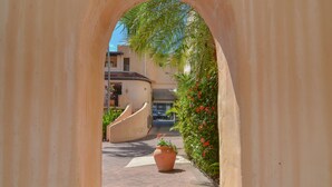 A narrow pathway leading to a building with a large archway. - Villa San Michele (Port Douglas)