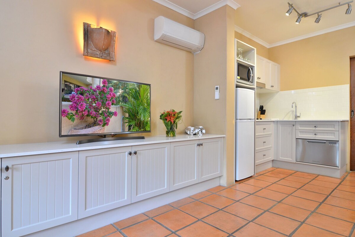 A modern kitchen with white cabinetry, a built-in oven, and a microwave.